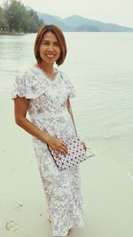 Portrait of smiling young woman standing in lake