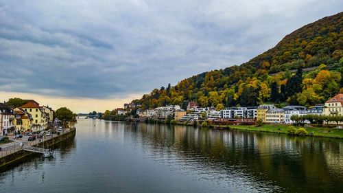 Scenic view of river by buildings against sky