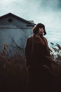 Portrait of woman standing on field against sky