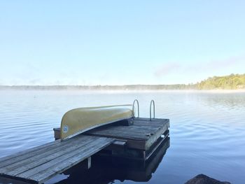 Pier over lake against clear sky