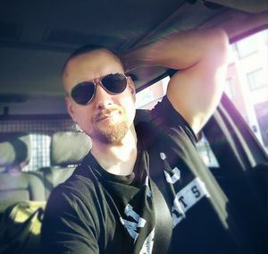 Young man wearing sunglasses in car