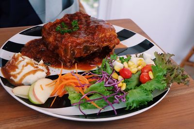 High angle view of meal served in plate on wooden table
