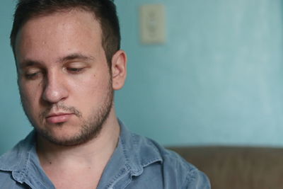 Close-up portrait of young man against wall