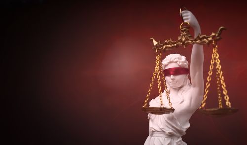 Justitia, the roman goddess of justice with red blindfold. panoramic image with copy space.