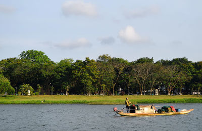 Scenic view of trees by river against sky