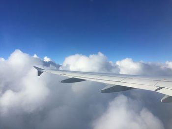 Airplane wing against cloudy sky