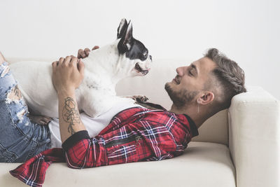 Man with dog on sofa against white background