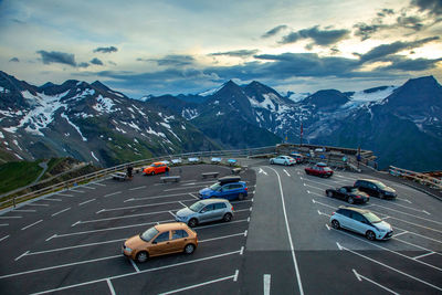 Traffic on road by mountains against sky