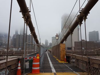 Bridge and buildings against sky during foggy weather