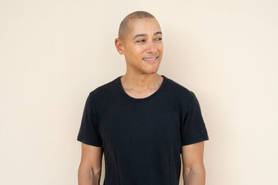 Portrait of young man standing against white background