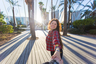 Portrait of young woman standing on boardwalk