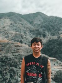 Portrait of smiling man standing on mountain