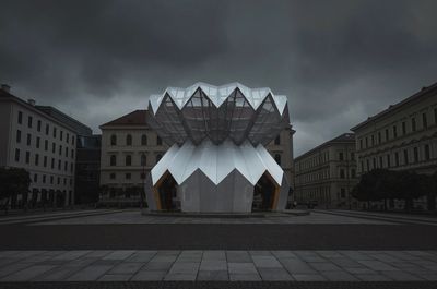 Buildings in city against cloudy sky