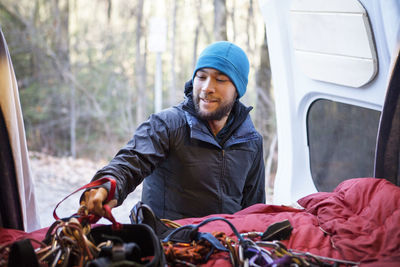 Man taking rock climbing equipment from camper van