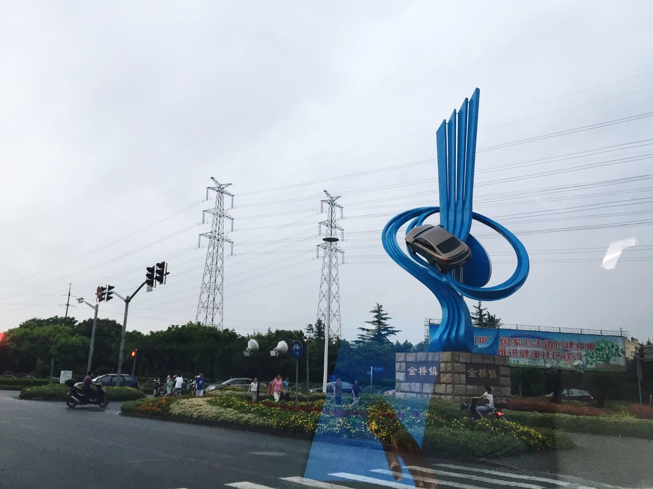 building exterior, architecture, built structure, sky, street, power line, road, city, transportation, electricity pylon, cable, car, street light, land vehicle, day, electricity, outdoors, power supply, mode of transport, cloud