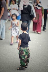 Rear view of people standing on street