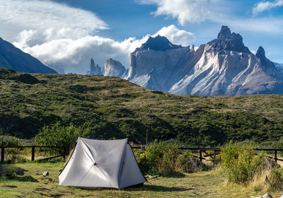 Tent on field against mountain range against sky