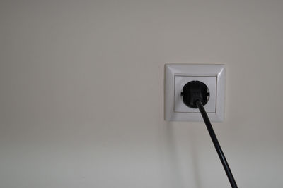 Close-up of electric lamp against wall at home