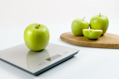 Ripe green apple on grey digital kitchen scales. healthy eating habits. healthy food concept