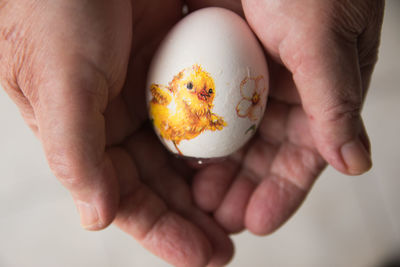 Mature woman holding decorated easter egg