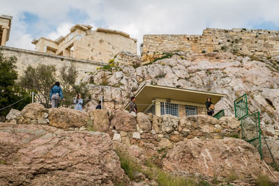 People on rock against building