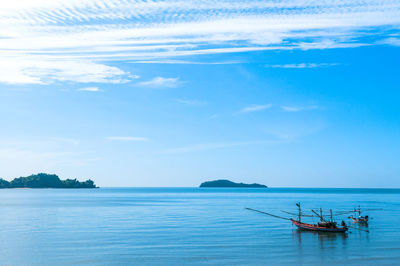 Fishing boats in blue sea, islands in background