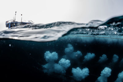 Close-up of boat moored on sea against sky