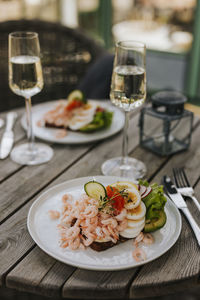 Prawn sandwiches and glasses of white wine on table