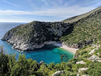 Scenic view of sea and mountains against sky