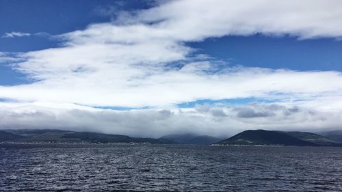 View of calm sea against mountain range