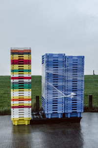 Stack of multi colored built structure by sea against clear sky