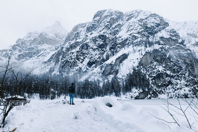 Snow covered land against mountain range