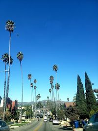 Cars on road against clear blue sky