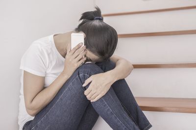 Midsection of woman using mobile phone while sitting at home