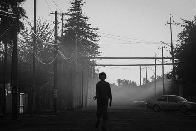Rear view of man on road against sky