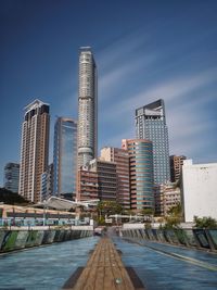 Modern buildings in city against blue sky
