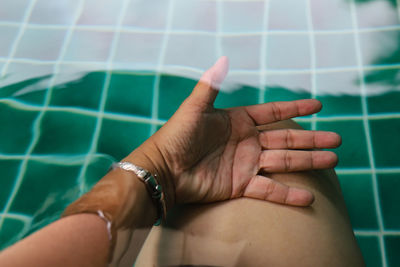 Close-up of people hand on swimming pool