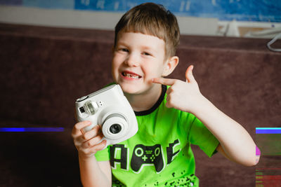 Portrait of boy holding camera