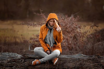 Portrait of young woman sitting on rock