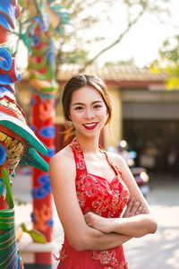 Portrait of smiling woman standing in city