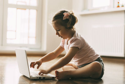 Side view of woman using mobile phone at home