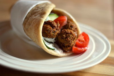 Close-up of falafels in wrap sandwich on plate