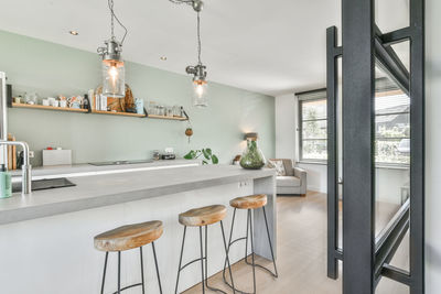 Illuminated pendant lights hanging on glass at home