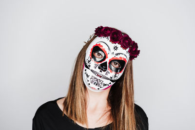 Portrait of woman wearing mask against white background