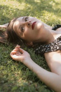 Portrait of young woman lying on grass