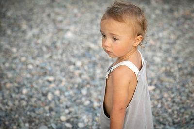 Portrait of cute boy standing on footpath