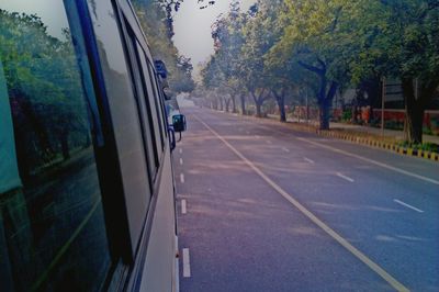 Close-up of cars on road against trees