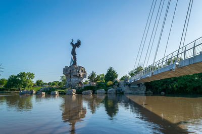 Statue of bridge over water against clear sky