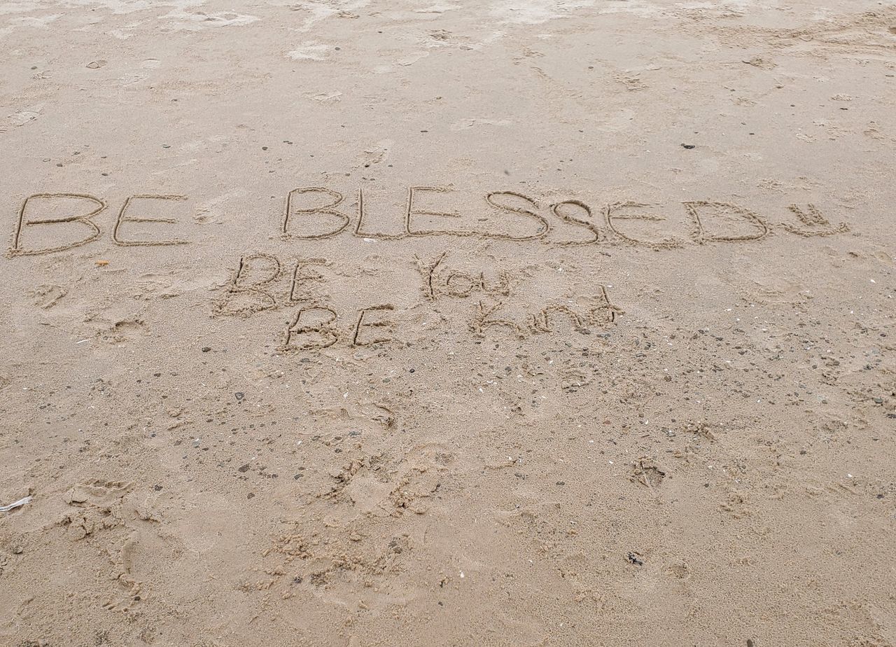 HIGH ANGLE VIEW OF TEXT ON BEACH