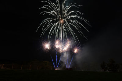 Low angle view of firework display at night